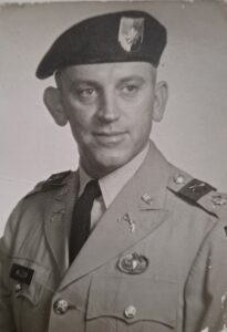 Black and white photo of a man in a green beret uniform.